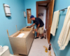 Reliable Cabinets worker installs a new bathroom cabinet with vessel sink